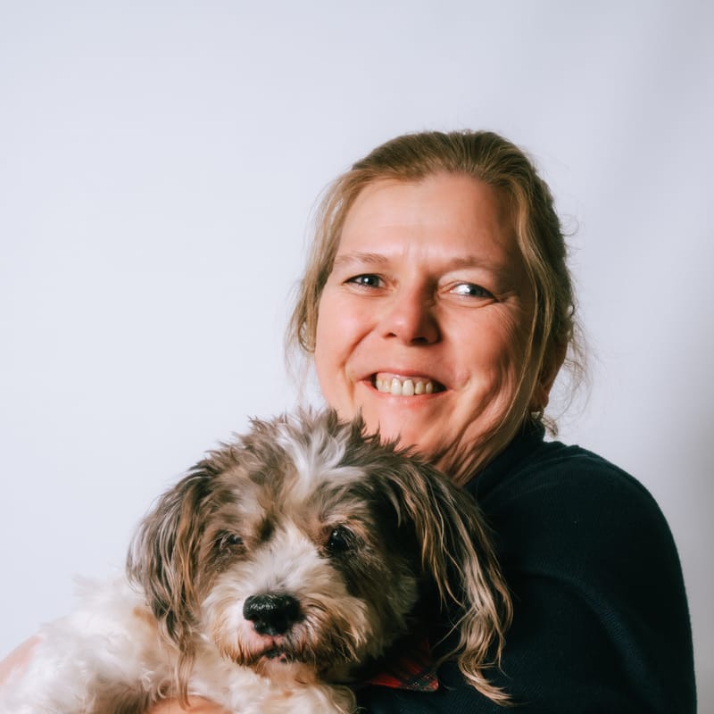 Porträt von Marion K. mit ihrem Hund auf dem Arm